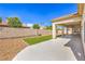 A covered patio with a ceiling fan looks onto a low-maintenance backyard featuring a rock garden and artificial turf at 7410 Bridlehorne Ave, Las Vegas, NV 89131