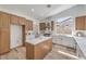 Modern kitchen with a center island, wood cabinets, stone countertops, and stainless steel appliances at 7410 Bridlehorne Ave, Las Vegas, NV 89131