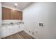 The laundry room features modern wood-look floors, upper cabinets, and white lower cabinets with a counter at 7410 Bridlehorne Ave, Las Vegas, NV 89131