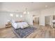 This main bedroom features wood floors, a modern chandelier, three accent windows, and neutral walls at 7410 Bridlehorne Ave, Las Vegas, NV 89131