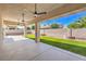 A covered patio with ceiling fans, overlooking a low-maintenance backyard with synthetic grass at 7410 Bridlehorne Ave, Las Vegas, NV 89131