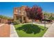 Two-story home with desert landscaping, lawn, neutral-toned exterior paint, and tiled roof at 7690 Morning Lake Dr, Las Vegas, NV 89131