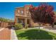 Two-story home with desert landscaping, green lawn, and neutral exterior paint at 7690 Morning Lake Dr, Las Vegas, NV 89131