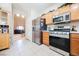 Bright kitchen with stainless steel appliances, wooden cabinets, and an adjacent living space at 7690 Morning Lake Dr, Las Vegas, NV 89131
