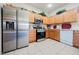 Well-lit kitchen with stainless steel refrigerator and appliances, bright countertops, and wooden cabinets at 7690 Morning Lake Dr, Las Vegas, NV 89131