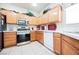 This kitchen features wooden cabinets, stainless steel appliances, and tile flooring at 7690 Morning Lake Dr, Las Vegas, NV 89131