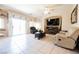 Cozy living room features tile floors, a ceiling fan, and a sliding glass door for bright natural light and easy access at 7690 Morning Lake Dr, Las Vegas, NV 89131