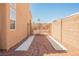 Side yard with gravel and concrete pathway leading to a secure gate, perfect for added privacy at 7690 Morning Lake Dr, Las Vegas, NV 89131