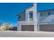Eye-level view of two-story modern homes with minimalist exteriors and attached garages on a sunny day at 9756 Rock Cliff St, Las Vegas, NV 89141