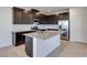 Kitchen with white island, stainless appliances, pendant lights, wood cabinets, and hardwood floors at 9756 Rock Cliff St, Las Vegas, NV 89141