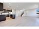 Open concept living room and kitchen with island, white walls, recessed lighting, and light wood floors at 9756 Rock Cliff St, Las Vegas, NV 89141