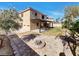 This backyard features a large pergola with stone patio and built in fire pit at 983 Plantain Lily Ave, Las Vegas, NV 89183