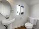 Cozy bathroom featuring white fixtures, a pedestal sink, and a round mirror at 983 Plantain Lily Ave, Las Vegas, NV 89183