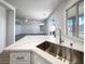 Modern kitchen with stainless sink, quartz countertops, and view to backyard at 983 Plantain Lily Ave, Las Vegas, NV 89183
