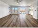 Open-concept living room with luxury vinyl plank flooring, a ceiling fan, and access to the backyard through sliding glass doors at 983 Plantain Lily Ave, Las Vegas, NV 89183