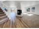 Bright living room featuring a modern fireplace, wood flooring, and access to the backyard through sliding glass doors at 983 Plantain Lily Ave, Las Vegas, NV 89183