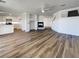 Open-concept floor plan showcasing luxury vinyl plank flooring, fireplace, and kitchen with modern white cabinets at 983 Plantain Lily Ave, Las Vegas, NV 89183