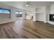 Open-concept living room featuring luxury vinyl plank flooring, fireplace, backyard access, and leading into a kitchen at 983 Plantain Lily Ave, Las Vegas, NV 89183