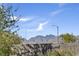 This backyard has low-maintenance landscaping and offers picturesque views of mountains beyond a modern block wall at 9903 Spinel Pl, Las Vegas, NV 89143
