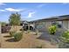This backyard features low-maintenance landscaping with gravel and flowering shrubs beneath windows with solar panels above at 9903 Spinel Pl, Las Vegas, NV 89143