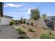 The well-maintained backyard is xeriscaped, featuring gravel, plants, and a modern block wall for privacy at 9903 Spinel Pl, Las Vegas, NV 89143