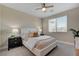 This primary bedroom has great natural light, a ceiling fan, and neutral carpet at 9903 Spinel Pl, Las Vegas, NV 89143