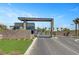 Modern community entrance with gated access, lush greenery, and palm tree accents at 9903 Spinel Pl, Las Vegas, NV 89143