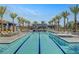 Resort-style pool with multiple tanning chairs, palm trees, and modern accents at 9903 Spinel Pl, Las Vegas, NV 89143