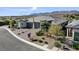 Single-Gathering home features a three-car garage, desert landscaping, and mountain views, showcasing modern living at 9903 Spinel Pl, Las Vegas, NV 89143