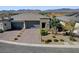 Expansive single-Gathering home with a three-car garage and desert landscaping showcasing curb appeal in a planned community at 9903 Spinel Pl, Las Vegas, NV 89143