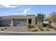 Charming single-story home with three-car garage, desert landscaping and tasteful stone accents at 9903 Spinel Pl, Las Vegas, NV 89143