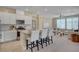 Bright kitchen overlooking the living area features white cabinets, an island with seating, and stainless appliances at 9903 Spinel Pl, Las Vegas, NV 89143