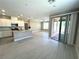 Open-concept living space with light-colored flooring, a modern kitchen, and sliding doors leading to an outdoor patio at 9903 Spinel Pl, Las Vegas, NV 89143