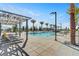 Stunning swimming pool area with lounge chairs, palm trees, and stylish pergolas for ultimate relaxation at 9903 Spinel Pl, Las Vegas, NV 89143