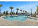 A beautiful swimming pool lined with palm trees, lounge chairs and shaded seating areas at 9903 Spinel Pl, Las Vegas, NV 89143