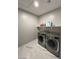 Functional laundry room equipped with a washer, dryer, and a shelf for storage at 10280 Midnight Meteor Ave, Las Vegas, NV 89166