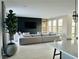 Living room featuring a large entertainment center, neutral color scheme, and a wall of windows at 10280 Midnight Meteor Ave, Las Vegas, NV 89166