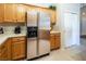 Kitchen with stainless steel refrigerator, oak cabinets, light countertops, and tan tile flooring at 10336 Birch Bluff Ln, Las Vegas, NV 89145