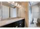Bathroom showcasing a double vanity with black cabinetry, framed mirror and tiled shower at 10512 Mann St, Las Vegas, NV 89141