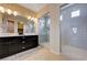 Bathroom featuring a double sink vanity and a walk-in shower with gray tiling at 10512 Mann St, Las Vegas, NV 89141