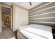 Bedroom with striped accent wall, carpet, closet and a view into the hallway at 10512 Mann St, Las Vegas, NV 89141