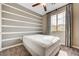 Bedroom with a queen size bed, striped accent wall, neutral paint, and a large window at 10512 Mann St, Las Vegas, NV 89141