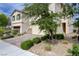 Lovely home with a two-car garage, stone accents, a paved driveway, and beautiful green landscaping at 10512 Mann St, Las Vegas, NV 89141