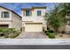 Inviting two-story home with a two-car garage and a beautifully paved driveway and stone accents at 10512 Mann St, Las Vegas, NV 89141