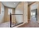 A hallway with carpeted stairs and a white and brown banister leading to the upper level of the home at 10512 Mann St, Las Vegas, NV 89141