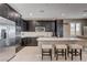 Modern kitchen with stainless steel appliances, dark cabinetry, and a center island with barstool seating at 10512 Mann St, Las Vegas, NV 89141