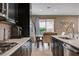 Modern kitchen featuring stainless steel appliances and view to the adjacent dining area with a patio at 10512 Mann St, Las Vegas, NV 89141