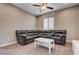 A comfortable living room with a large sectional couch, neutral carpet, and a centered coffee table creates a cozy atmosphere at 10512 Mann St, Las Vegas, NV 89141