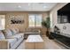 Cozy living room features a large gray sectional couch, modern decor, and ample natural light at 10512 Mann St, Las Vegas, NV 89141
