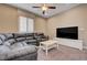 Spacious living room with a large sectional sofa, flat screen tv, and a white coffee table with neutral toned walls at 10512 Mann St, Las Vegas, NV 89141